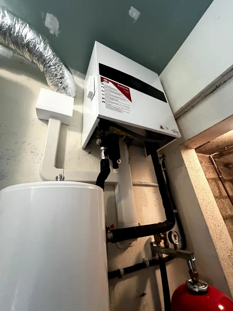 Module intérieur de pompe à chaleur au-dessus du ballon d'eau chaude, vase d'expansion rouge